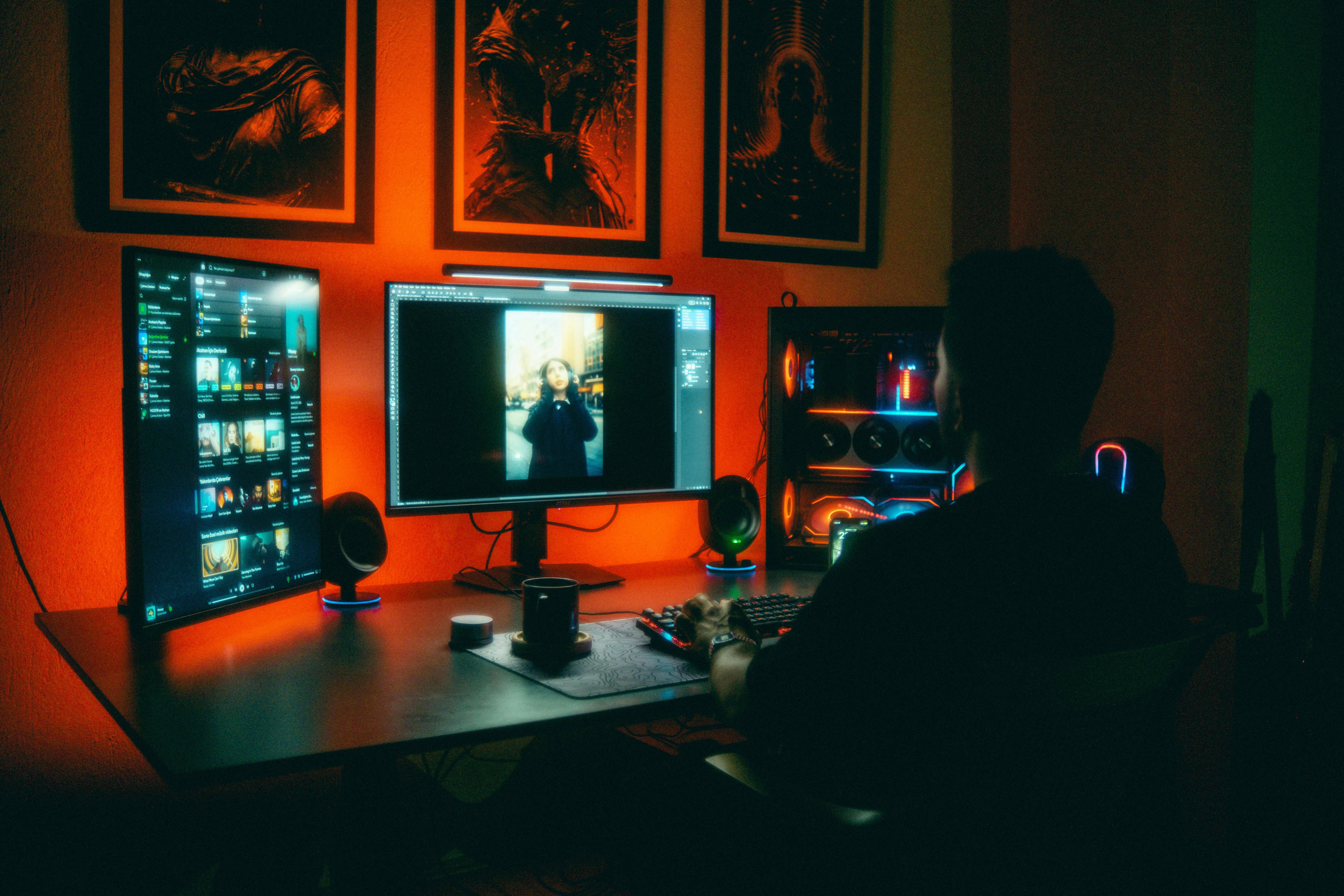 Free A person editing photos at night in a neon-lit home office with dual screens. Stock Photo