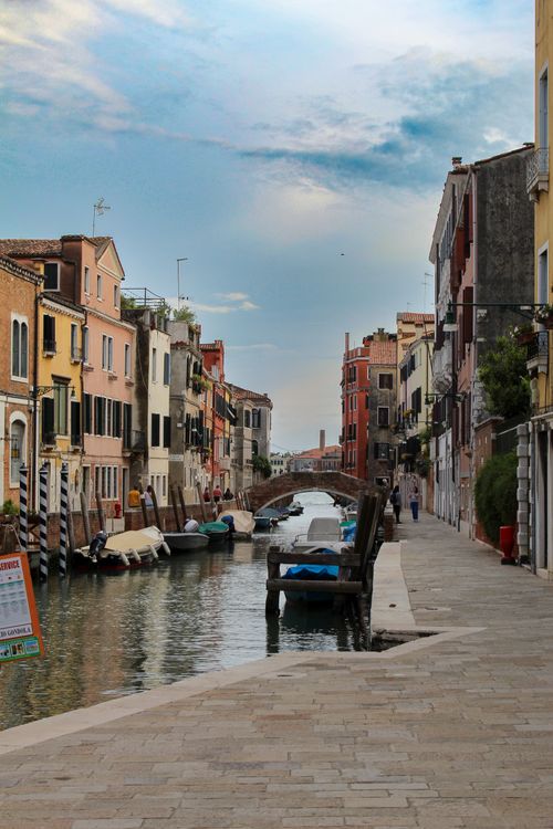 Free Charming view of a Venetian canal with colorful buildings and boats, reflecting a serene ambiance. Stock Photo