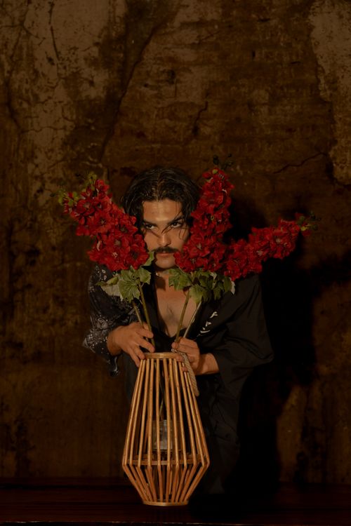 Dramatic Portrait with Red Flowers in Stylish Vase · Free Stock Photo