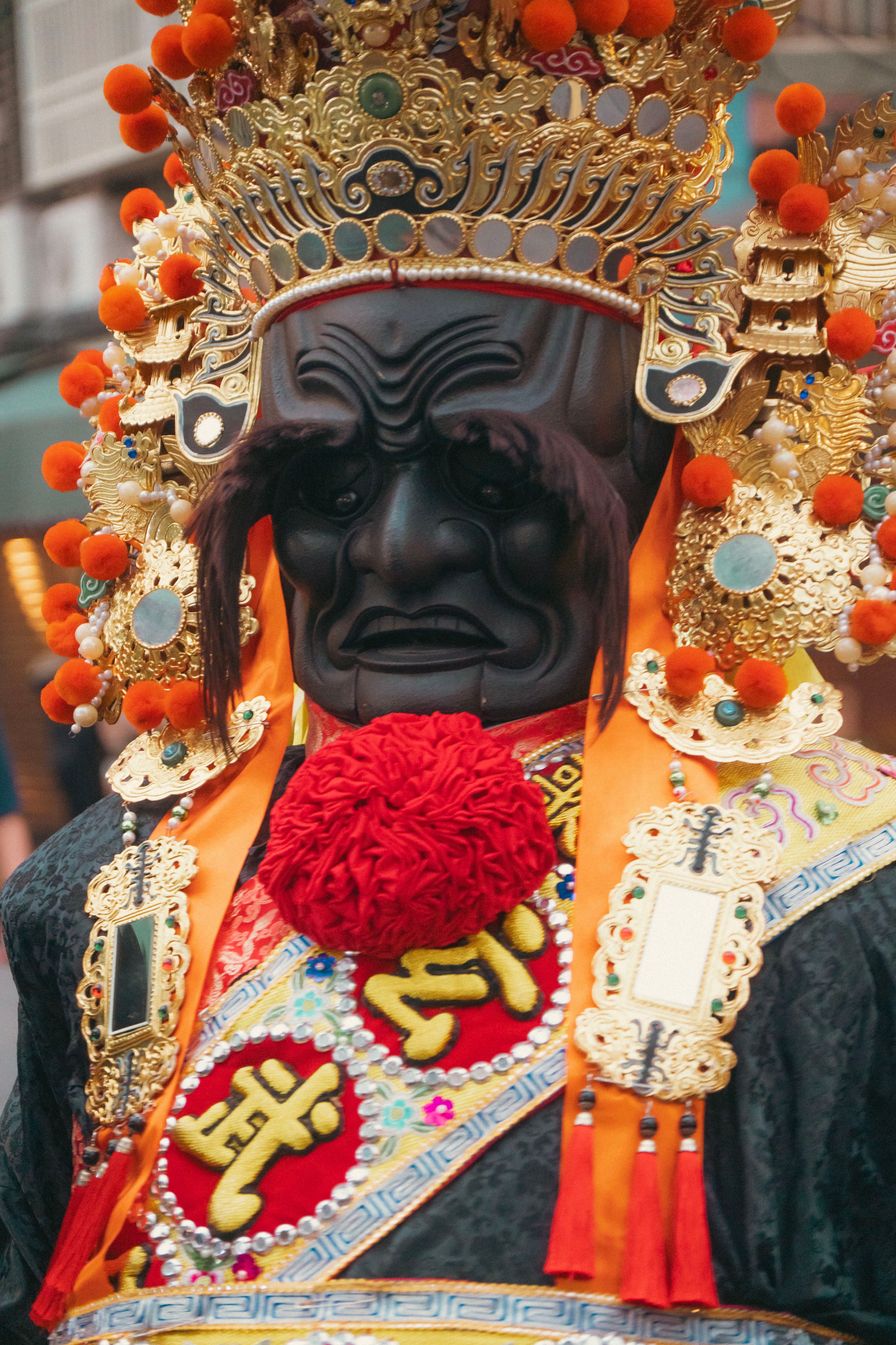 Close-up of ornate traditional Chinese festival costume with intricate designs and vibrant colors.