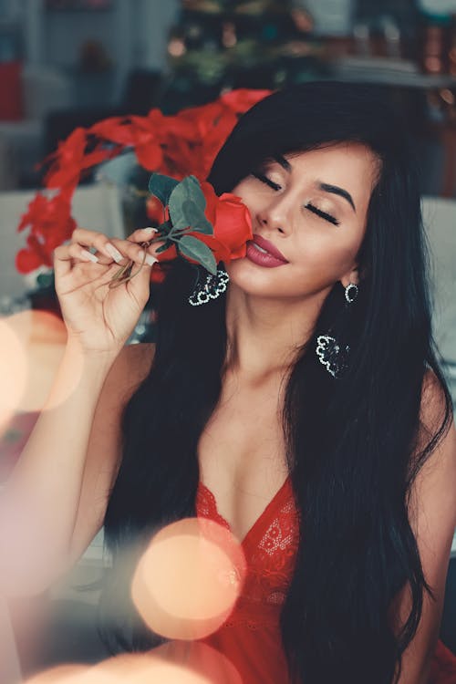 Woman in Red Floral Sheer Lace V-neck Top Holding Red Flower