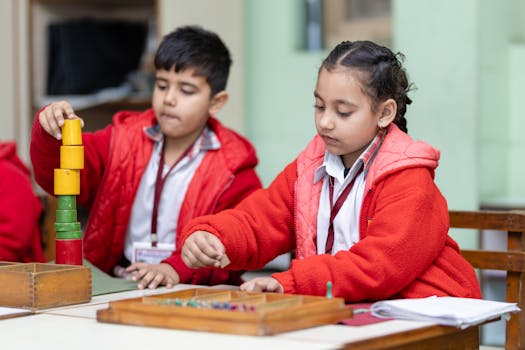 Two young children focus on educational activities at a classroom table.