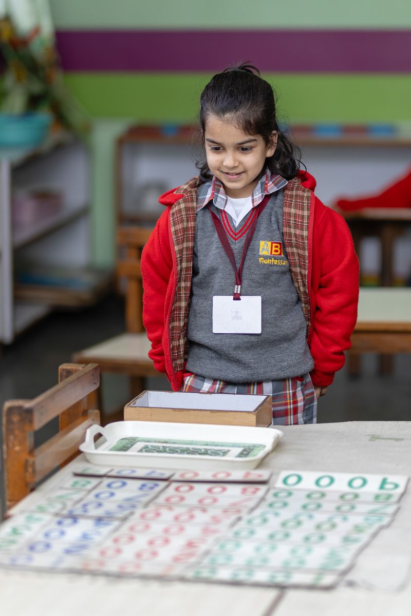 A child working carefully with Montessori learning materials