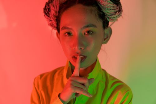 Free Creative portrait of a young Asian woman with colorful lighting in a trendy fashion pose. Stock Photo