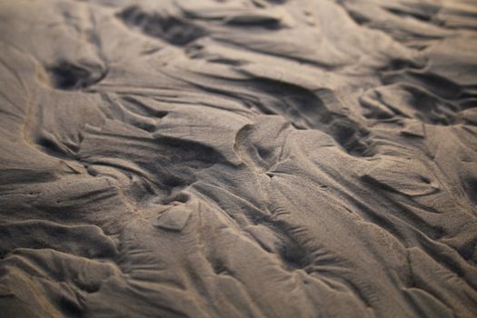 Close-up of natural sand patterns on a beach in Guaratuba, Paraná, Brazil, showcasing organic textures.