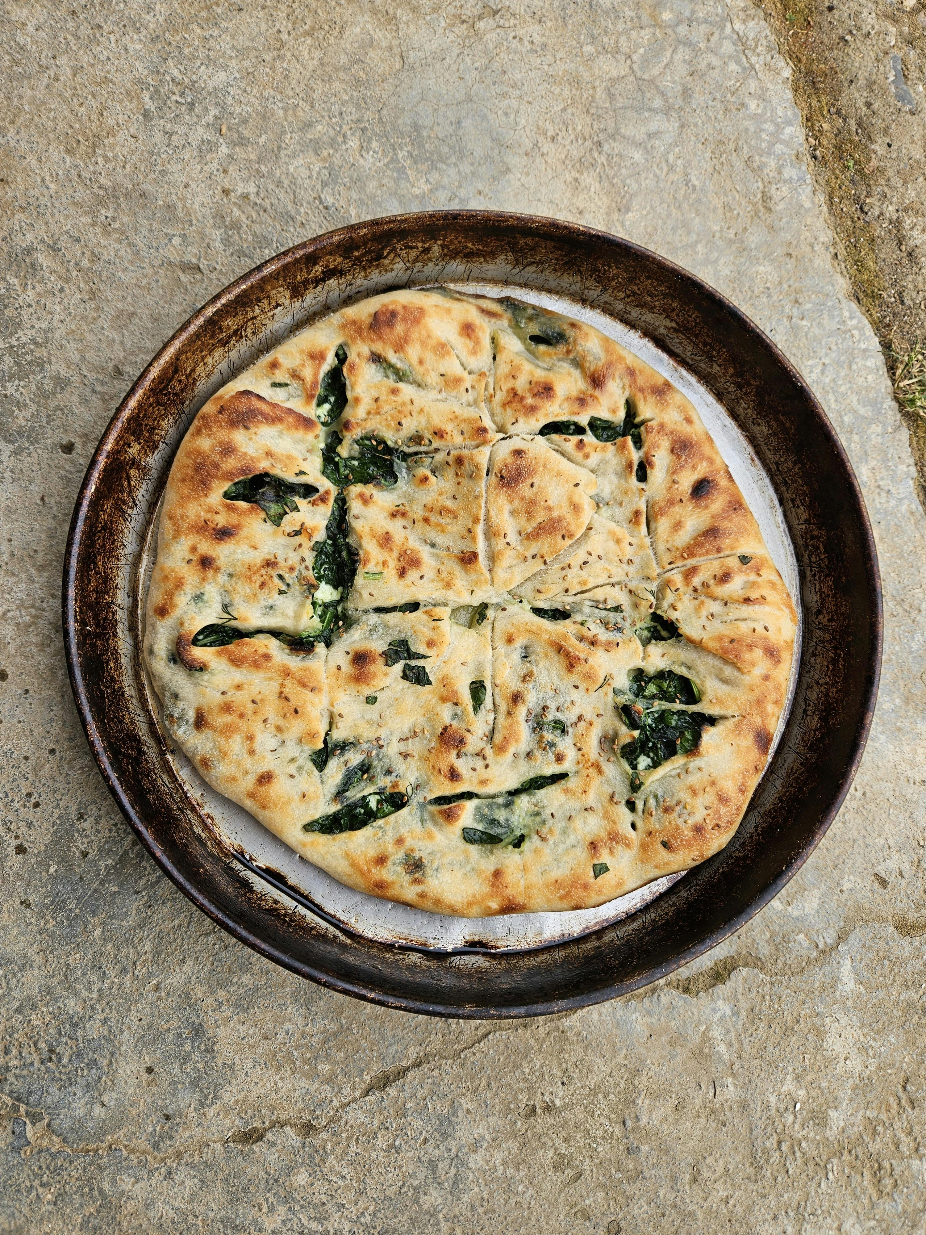 Hands kneading turmeric flatbread dough on a floured surface