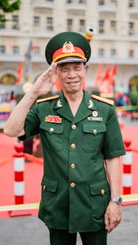 Senior military officer in green uniform saluting outdoors at a public event.
