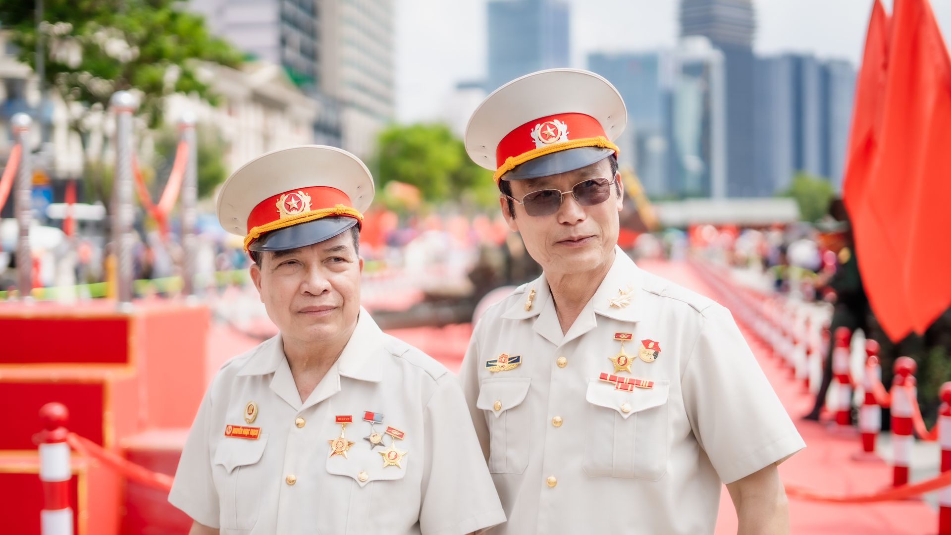 Two veterans in white uniforms and hats at a public celebration outdoors.
