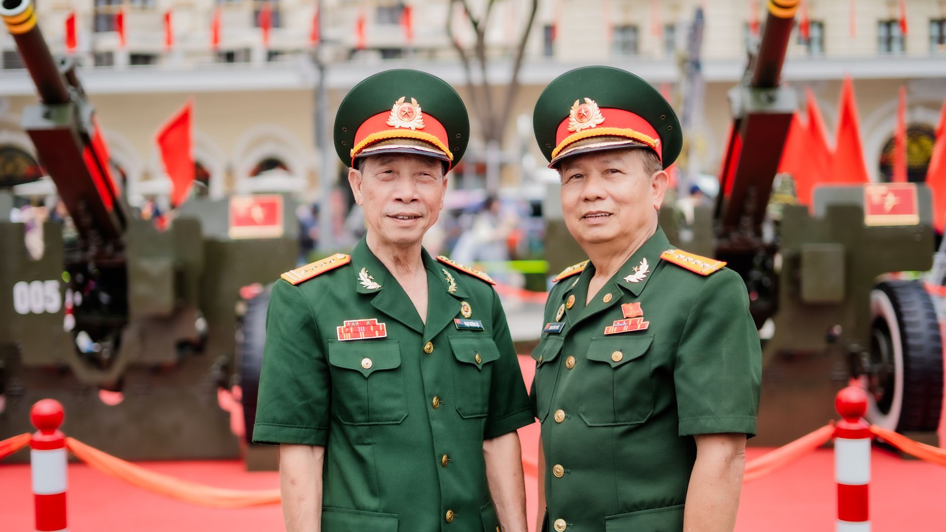 Two Vietnamese military officers in green uniforms standing outdoors at a formal ceremony.