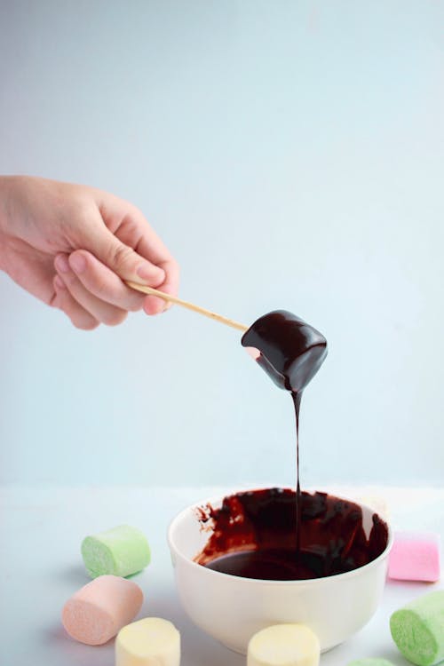 Free Photo Of Dipped Marshmallow On Melted Chocolate Stock Photo