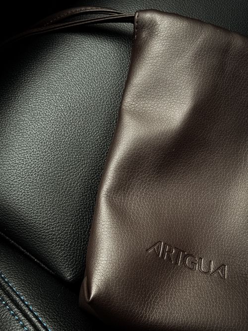 Free Elegant brown leather bag placed on a textured black leather background. Stock Photo