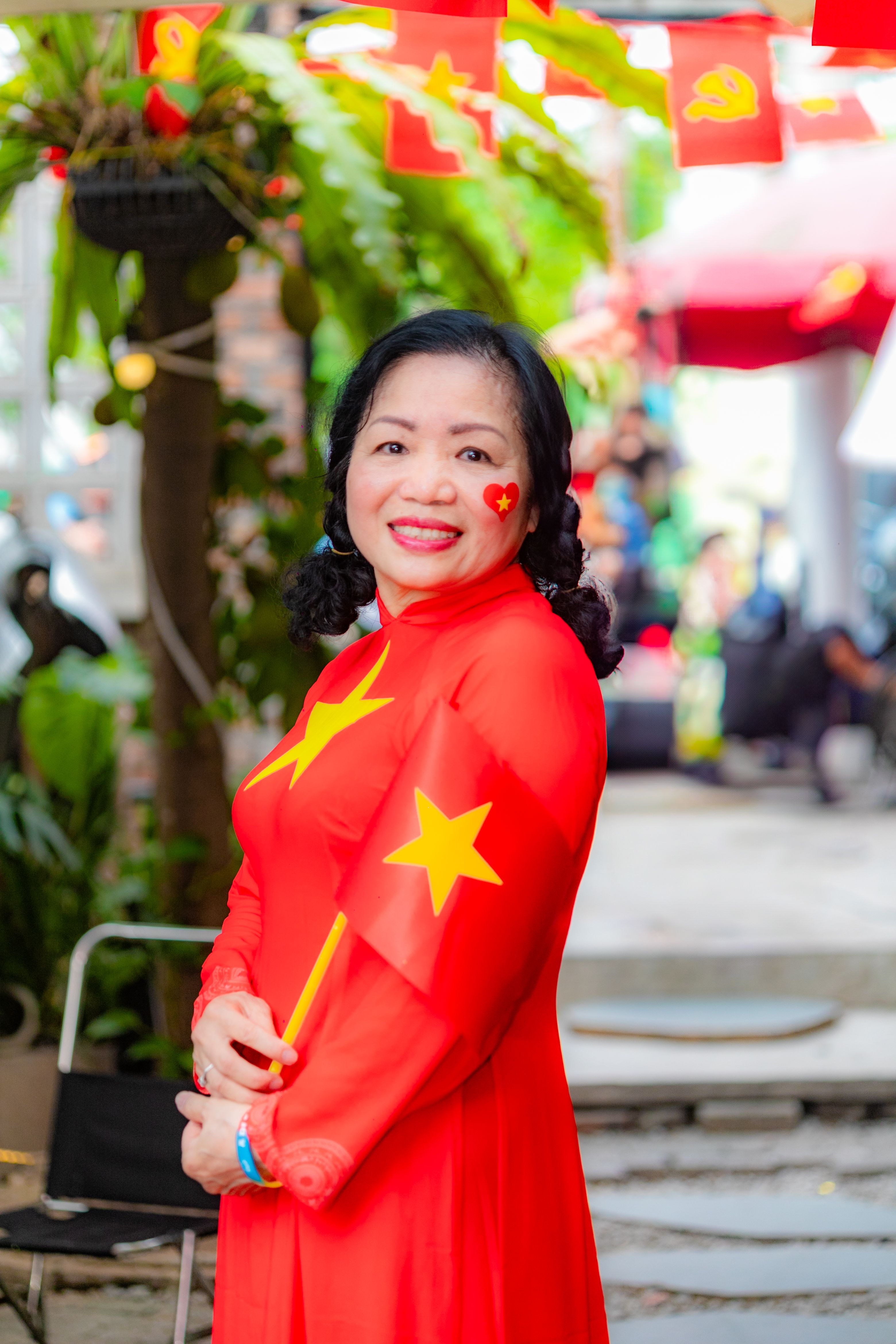 Smiling Vietnamese woman in traditional attire celebrating a national holiday, outdoors in Hải Phòng.