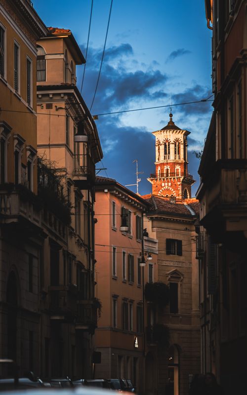 Free Charming streets of Verona with a view of historic tower illuminated at twilight. Stock Photo