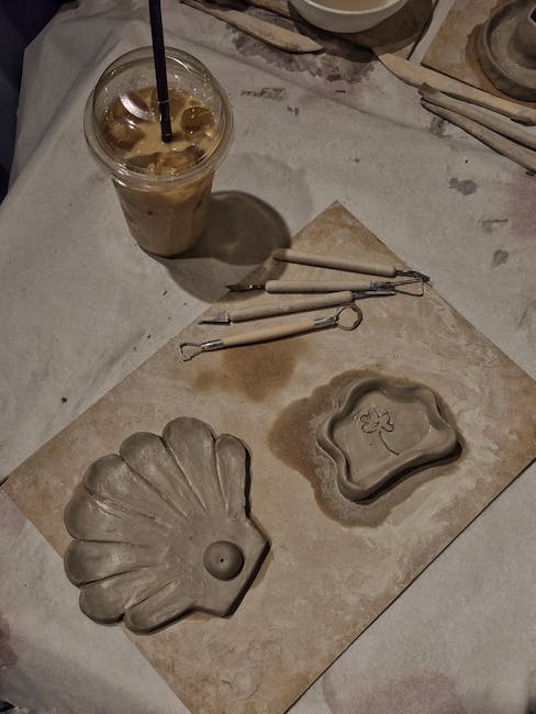 Flat lay of clay art with tools and iced coffee, highlighting creative artistry.