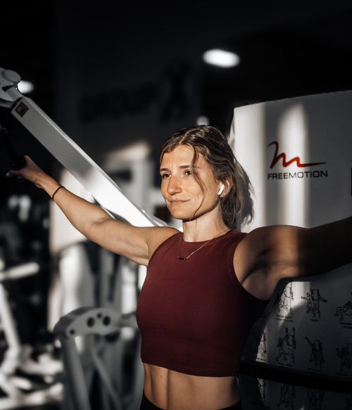 Free Focused woman using Freemotion machine in gym, emphasizing strength and fitness. Stock Photo