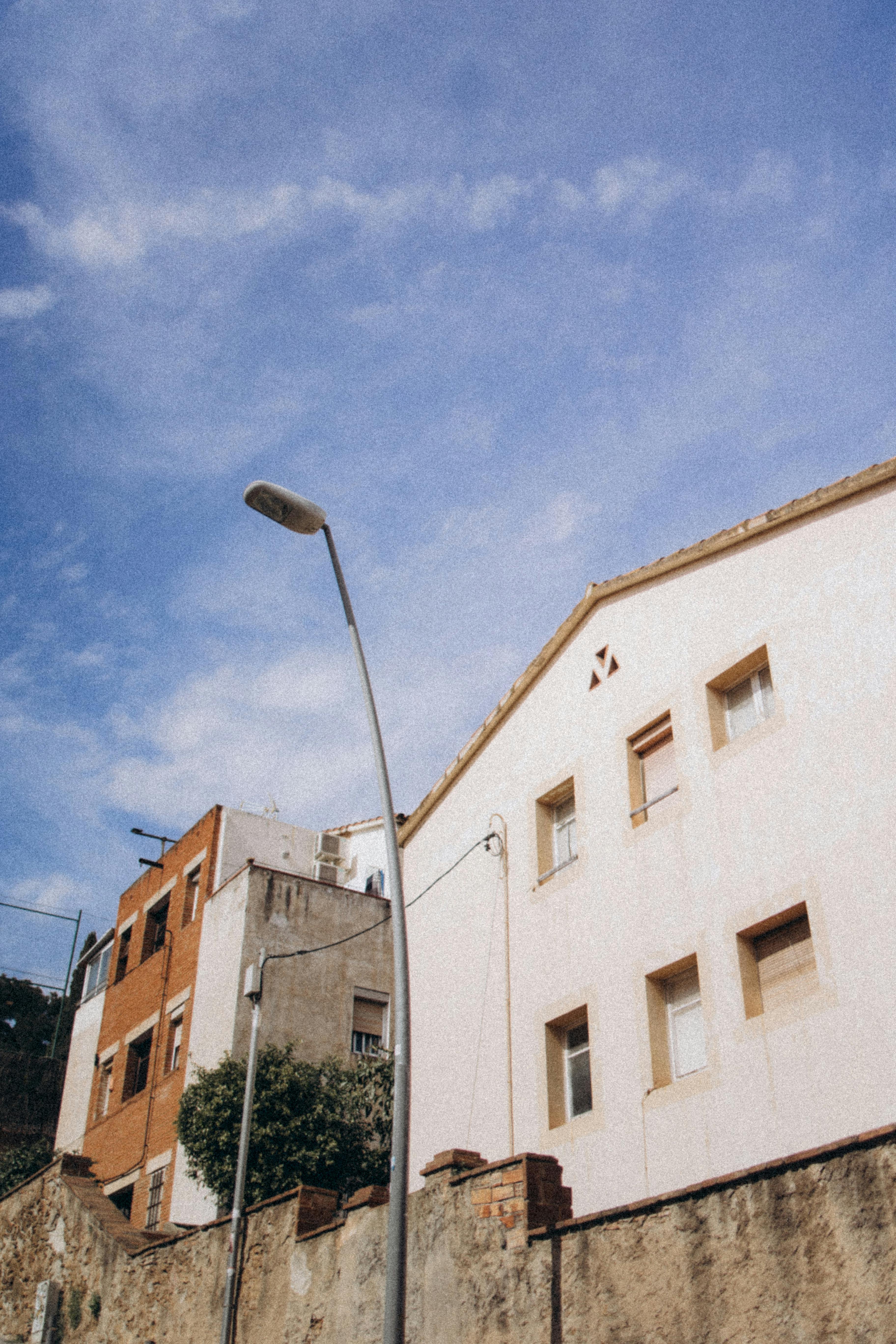 Ilmainen Kadunäkymä kaupunkien arkkitehtonisesta julkisivusta kirkkaan sinisen taivaan taustalla, esittelemässä moderneja ja vintage-rakennustyylejä. Kuvapankkikuva