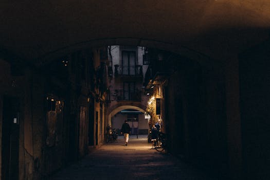 Moody alley at night with silhouettes and warm lighting creating intrigue and depth.