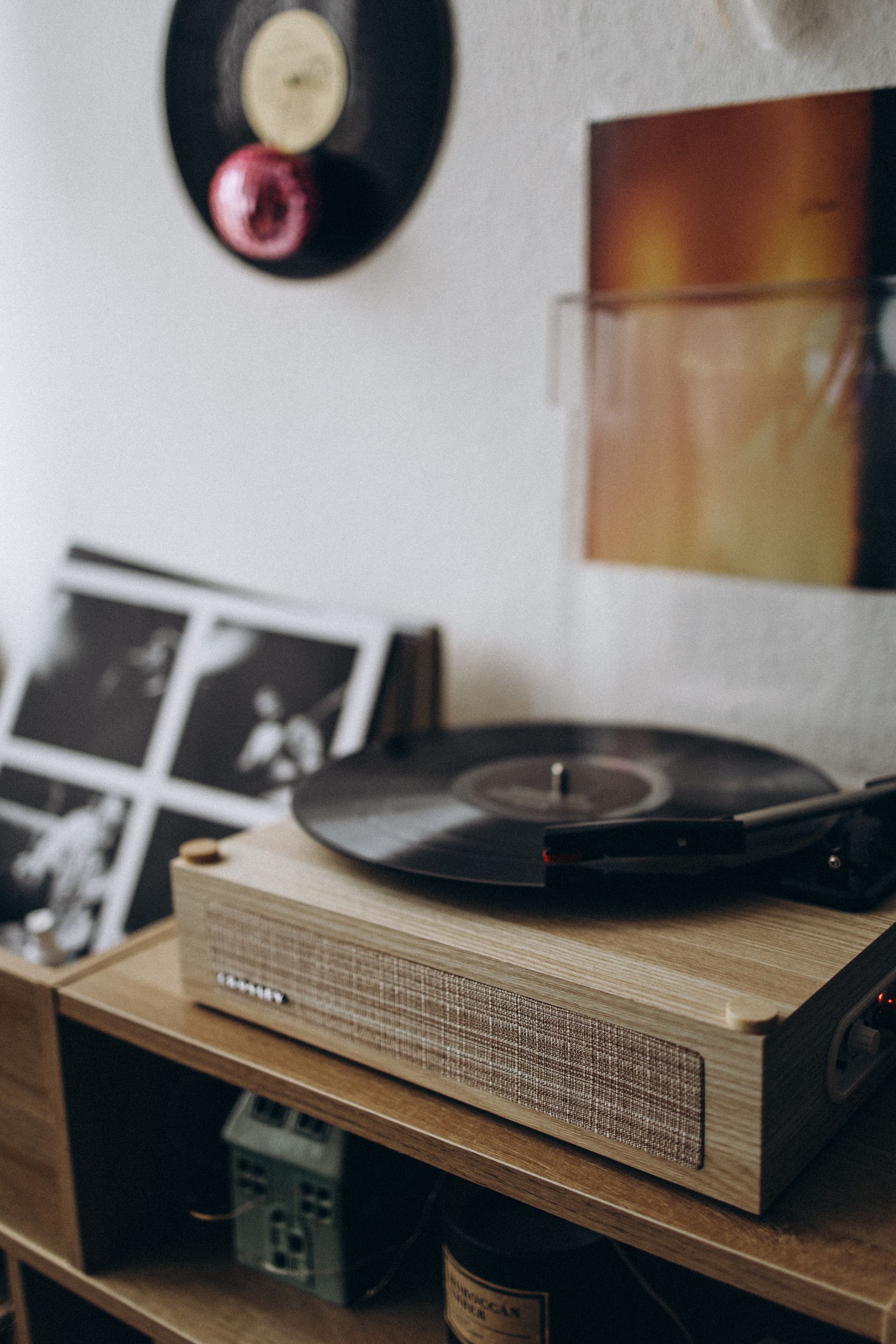 Wooden turntable on a dedicated surface with vinyl records stored below