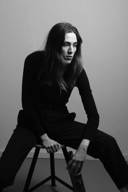 Artistic black and white portrait of a woman in a Berlin studio setting.