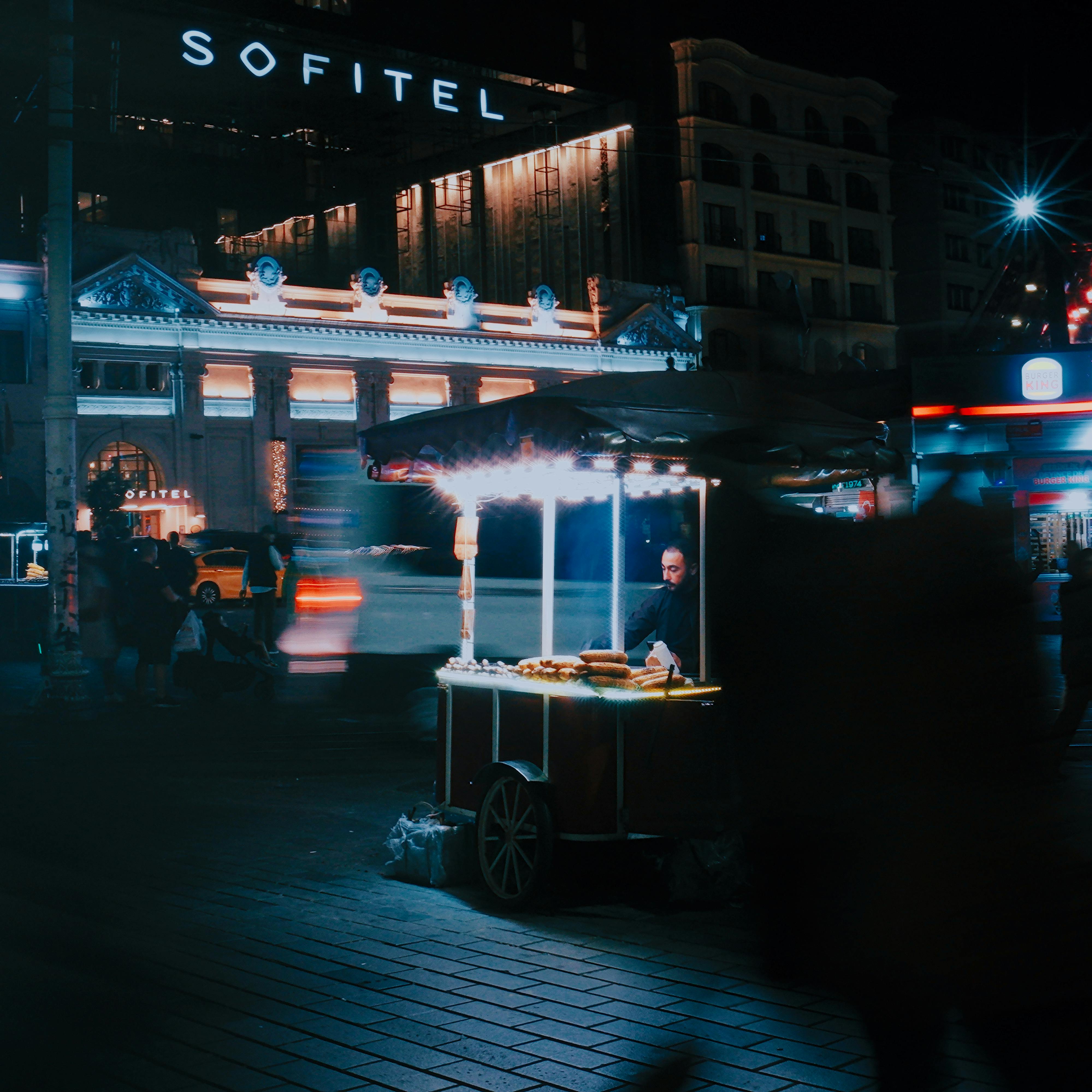 Busy urban night scene with a glowing street food cart in Istanbul.