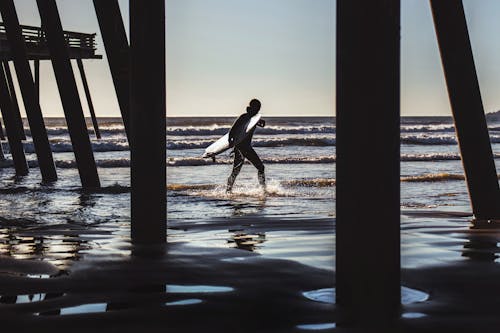 Surfista Camina Cerca Del Muelle En La Playa