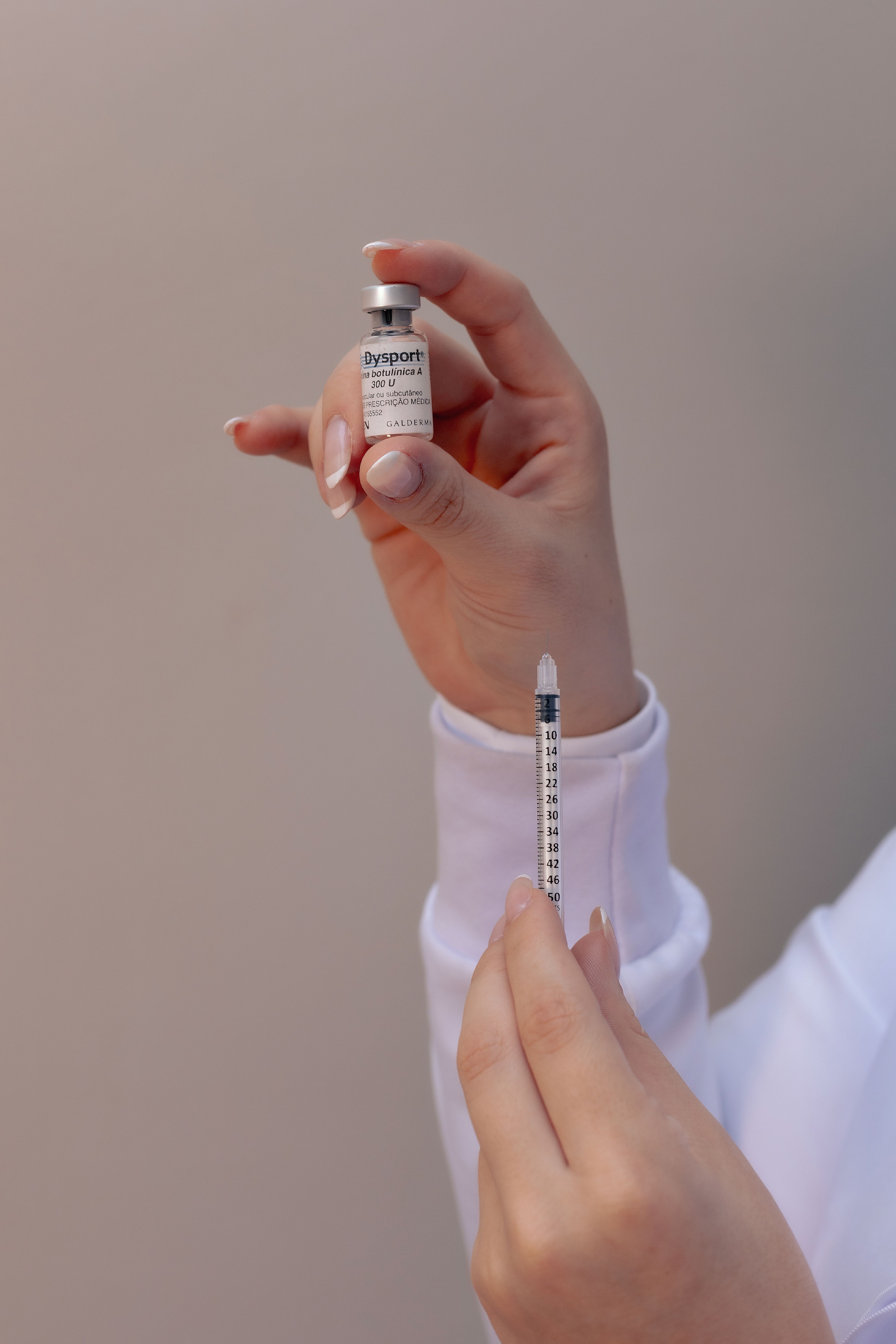 Close Up Tangan Memegang Botol Dan Suntikan Botox · Foto Stok Gratis