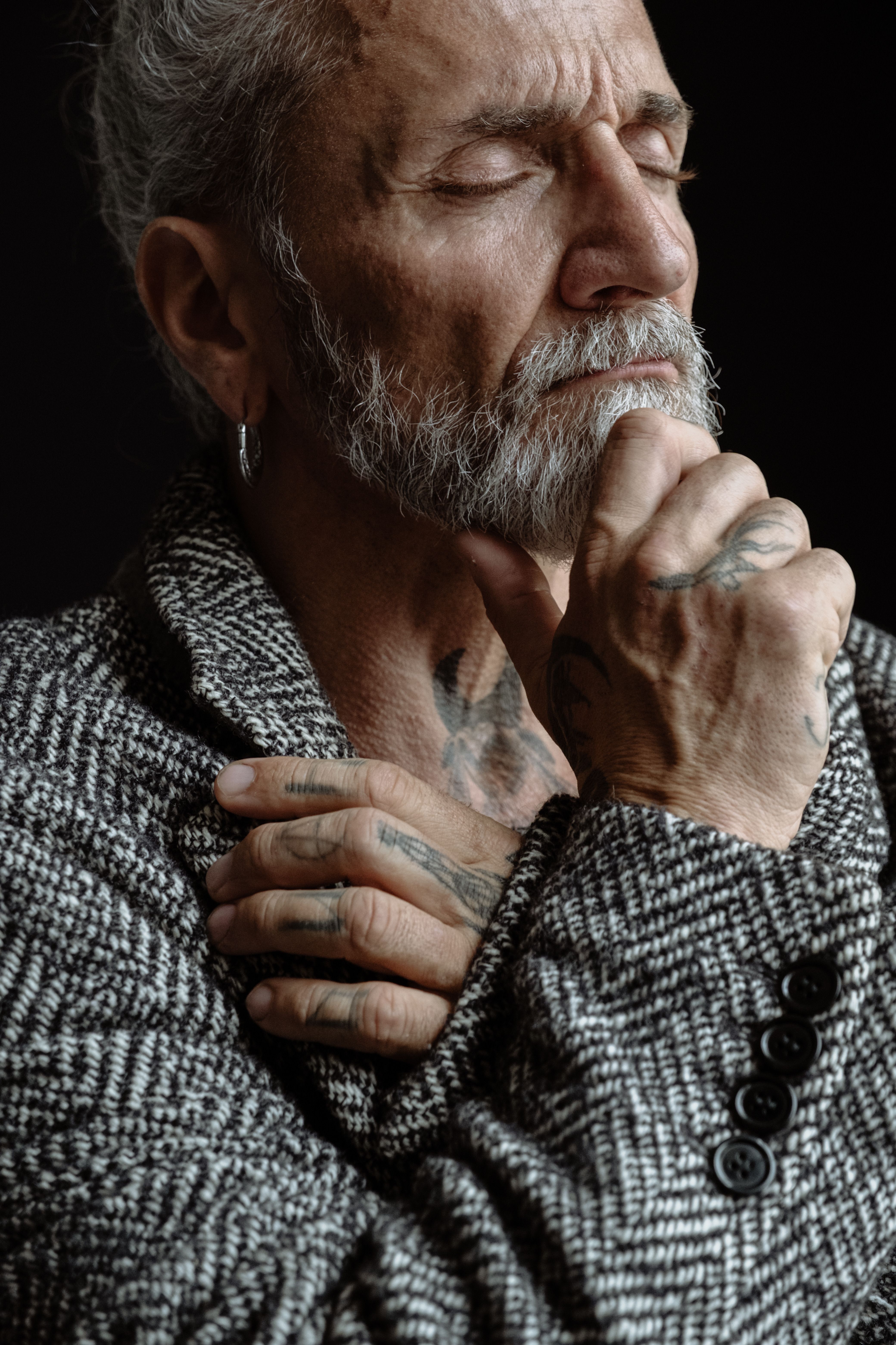 Pensive Senior Man with Tattoos Contemplating