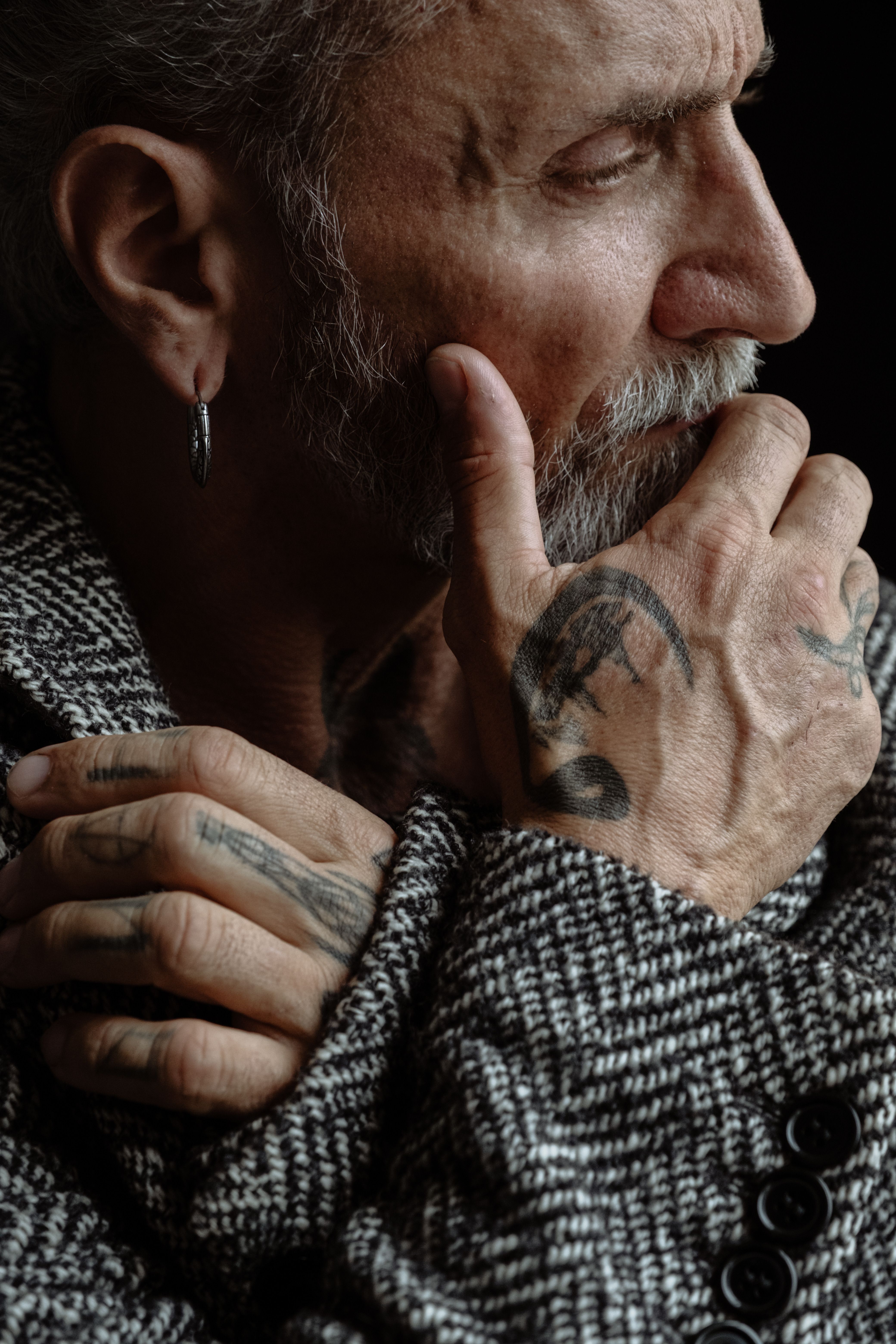 Thoughtful Senior Man with Tattoos in Tweed