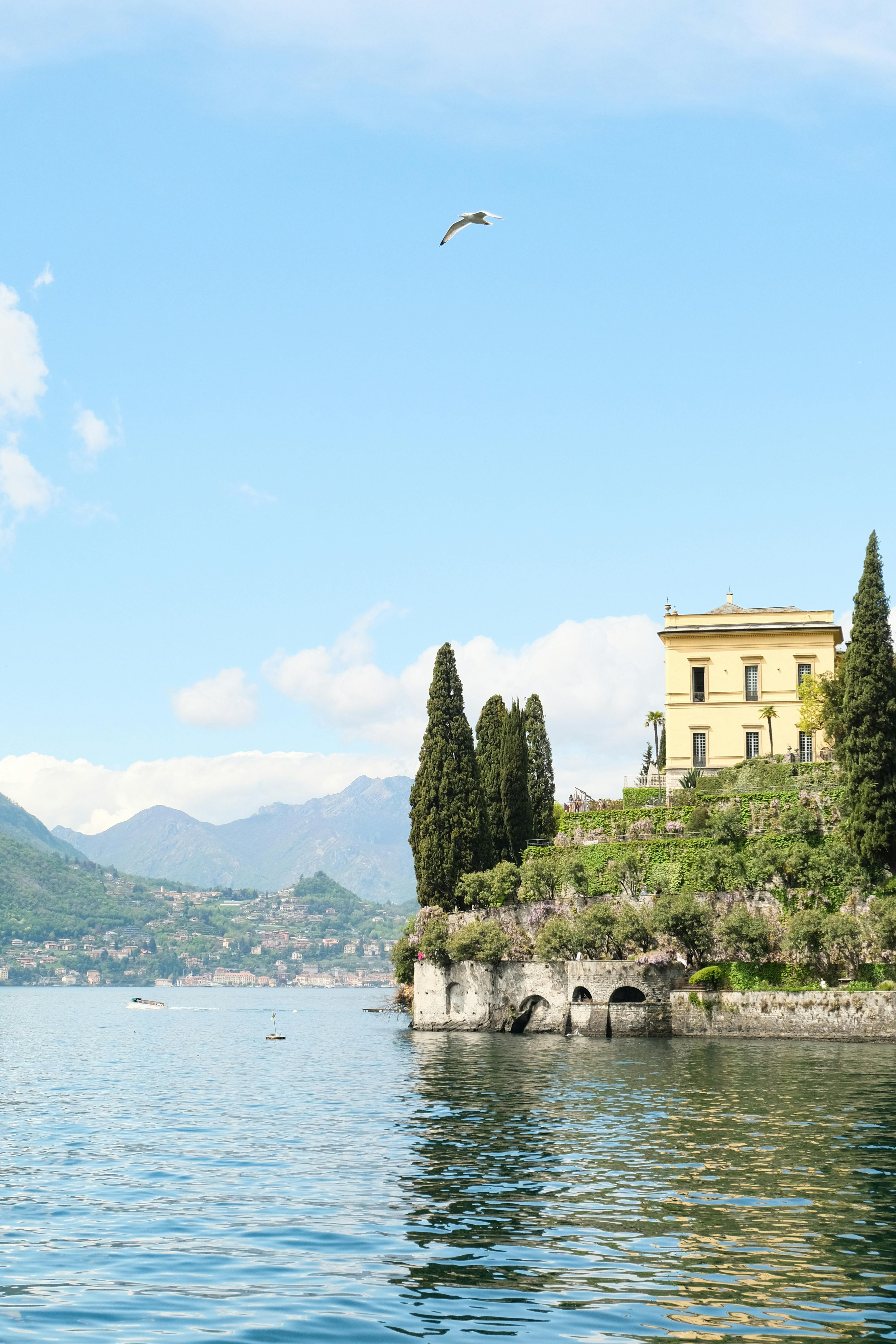 Elegant villa overlooking Lake Como with mountains and clear sky.