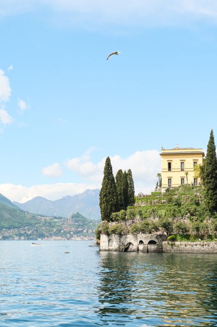 Elegant villa overlooking Lake Como with mountains and clear sky.