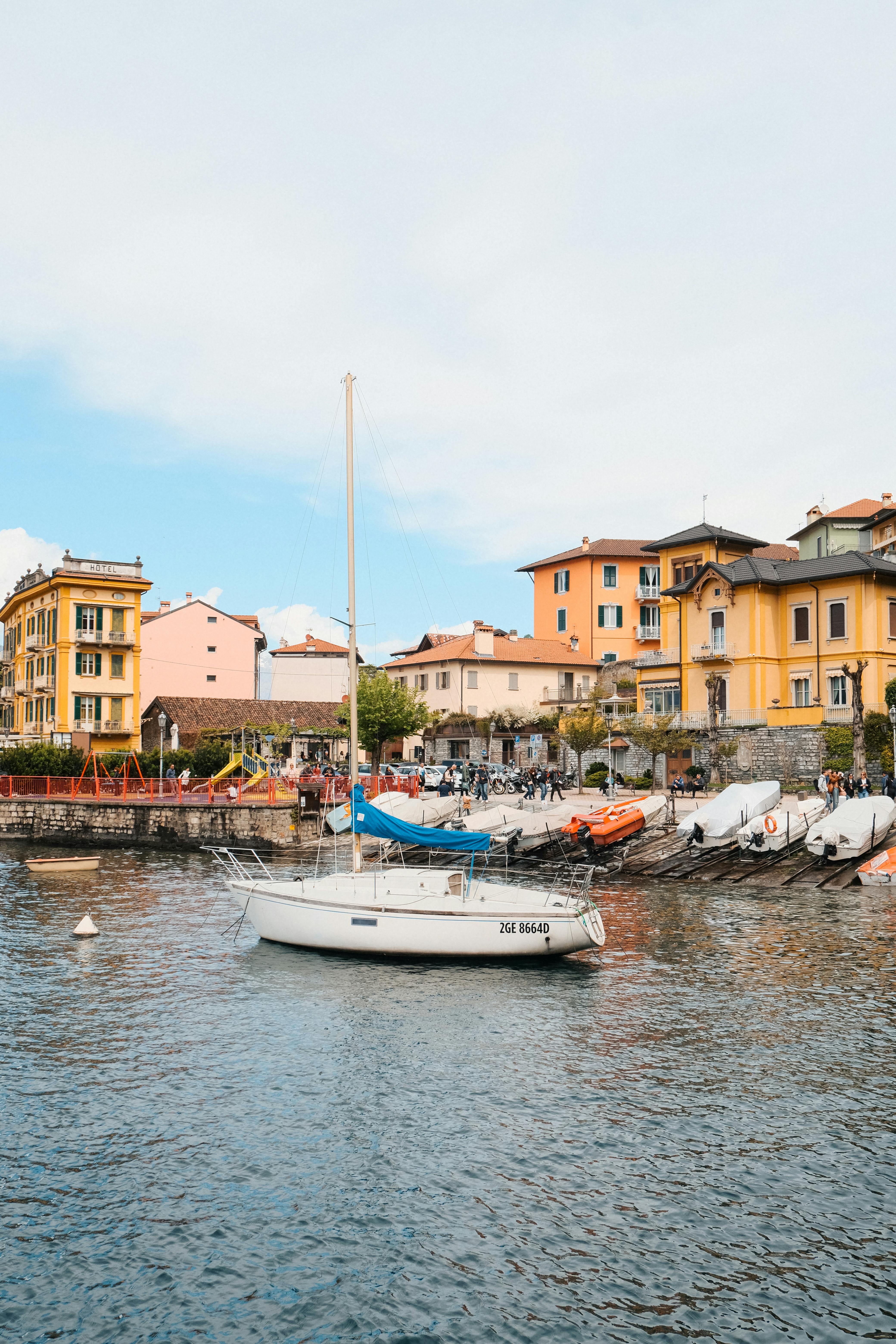 Charming waterfront scene on Lake Como with boats and vibrant architecture under a bright sky.