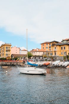 Charming waterfront scene on Lake Como with boats and vibrant architecture under a bright sky.