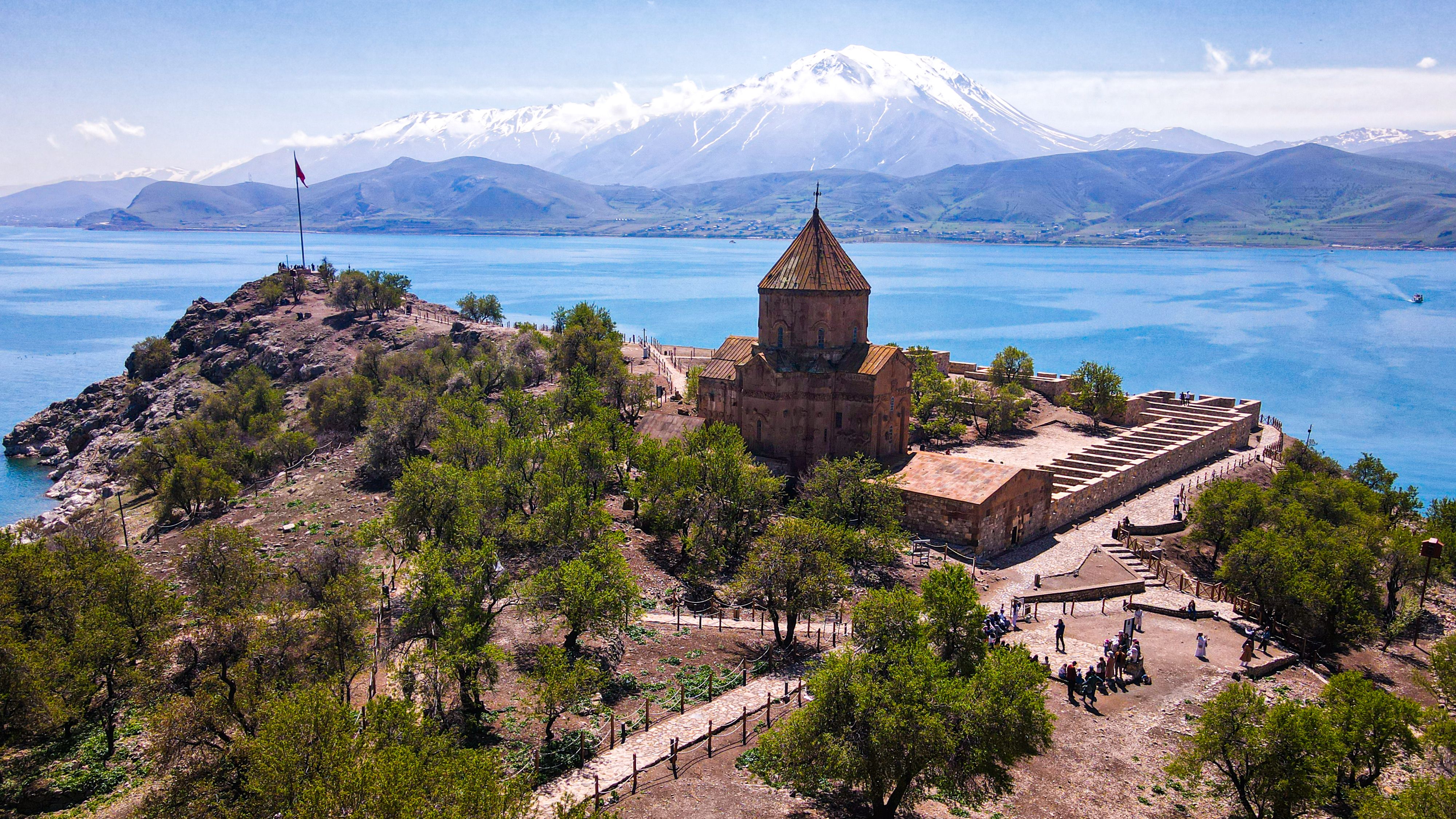 Turquoise waters of Lake Van with Akdamar Island church at sunset, eastern Turkey, ancient Armenian monastery against mountain backdrop