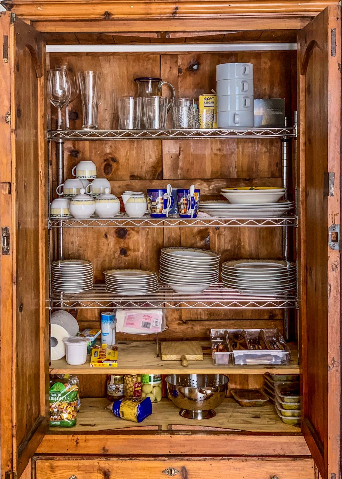 Organized kitchen cabinet with dishes glassware and pantry items