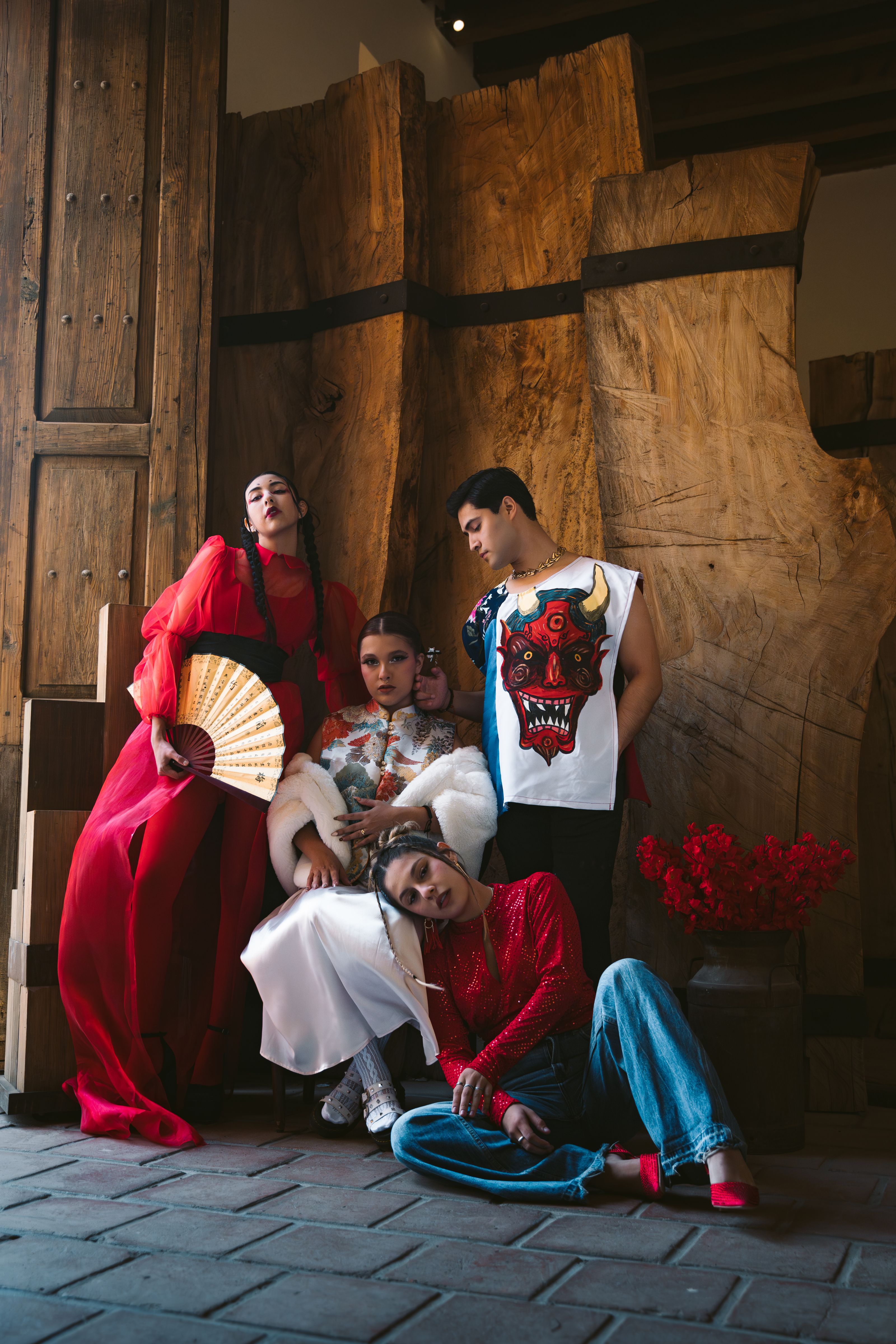 Grupo de modelos diversos em roupas vibrantes posando em um cenário rústico com fundo de madeira.
