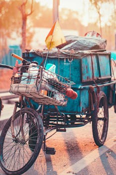 一辆生锈的三轮车停在阳光明媚的北京街道上，车上挂着彩色旗帜，镜头给了它一个特写