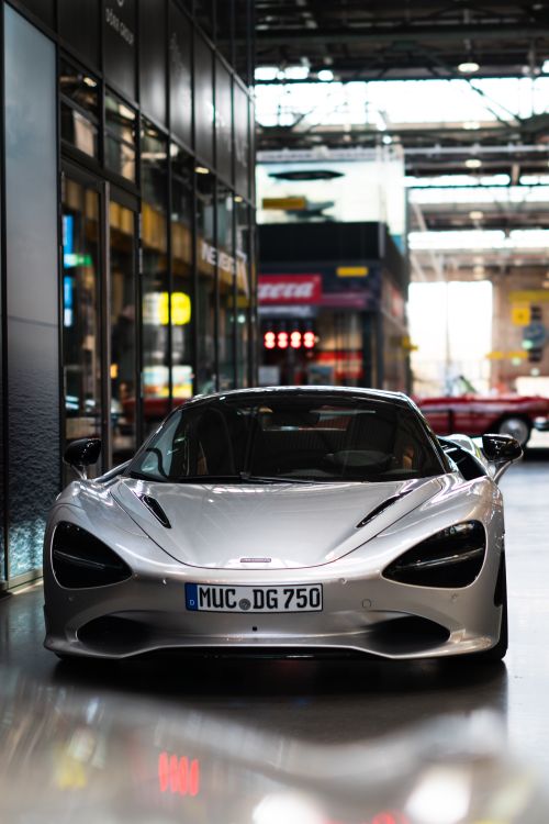 Free A stylish silver supercar parked indoors in a modern urban environment, showcasing sophistication. Stock Photo