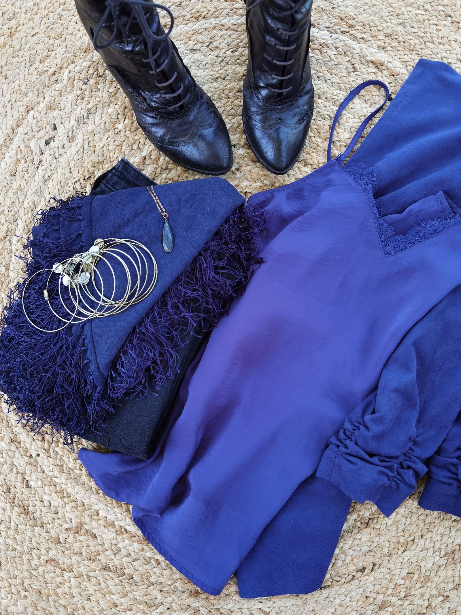 Blue silk blouse with accessories arranged in a flat lay without people