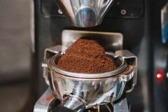 Detailed view of coffee grounds being prepared in a professional espresso machine in Shinjuku, Tokyo, Japan.