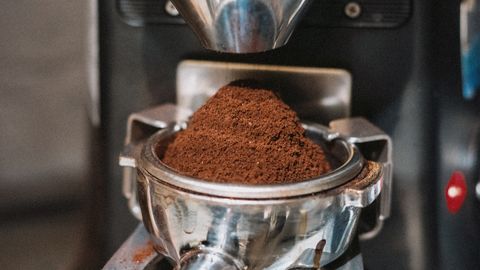 Detailed view of coffee grounds being prepared in a professional espresso machine in Shinjuku, Tokyo, Japan.