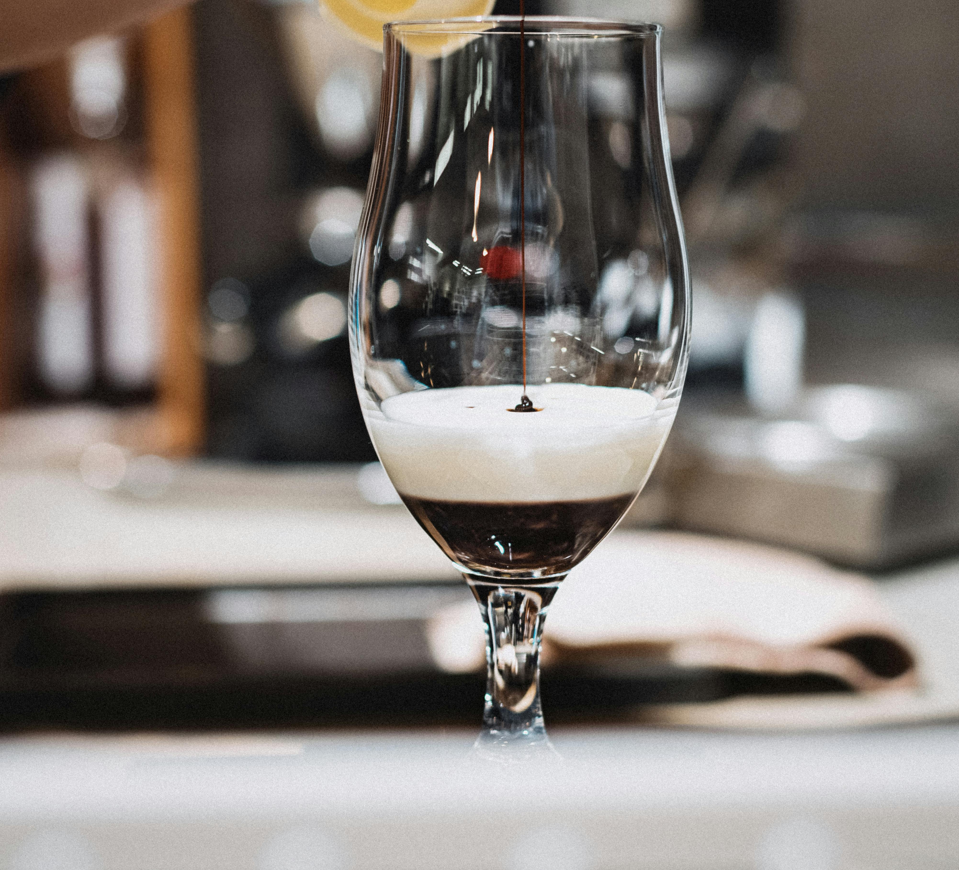 A close-up of a layered coffee drink being prepared by baristas in a Tokyo cafe.