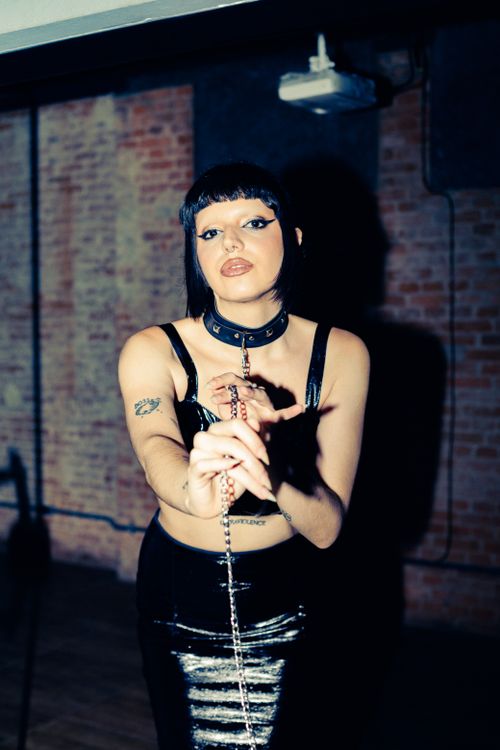 Free Edgy fashion portrait of a woman in a São Paulo studio with brick wall background. Stock Photo