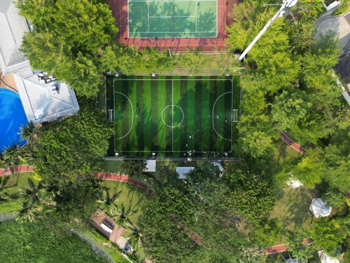 Free Aerial shot of a vibrant football field surrounded by trees in Ho Chi Minh City, Vietnam. Stock Photo