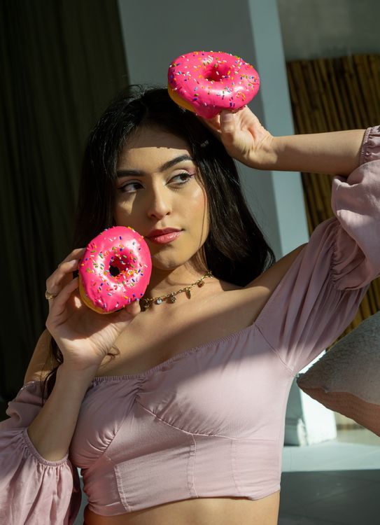 Sprinkle Pose Woman Posing with Colorful Donuts Indoors · Free Stock Photo