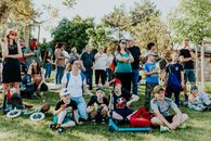 A diverse group of people enjoying a sunny day at an outdoor community event in a park setting.