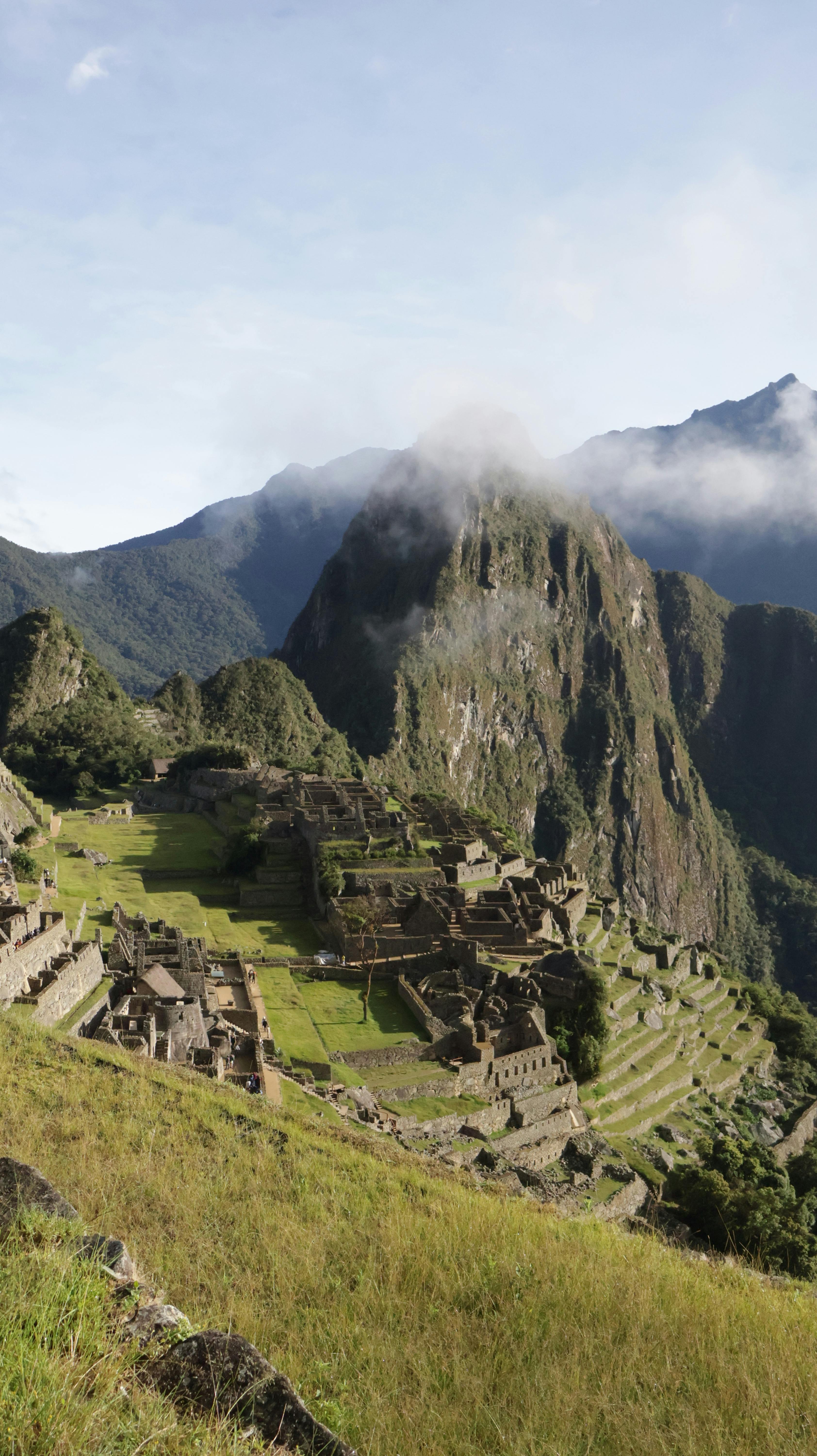 Capture of Machu Picchu overlooking lush mountains in early morning light.