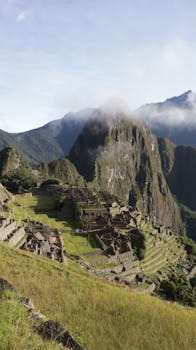 Capture of Machu Picchu overlooking lush mountains in early morning light.
