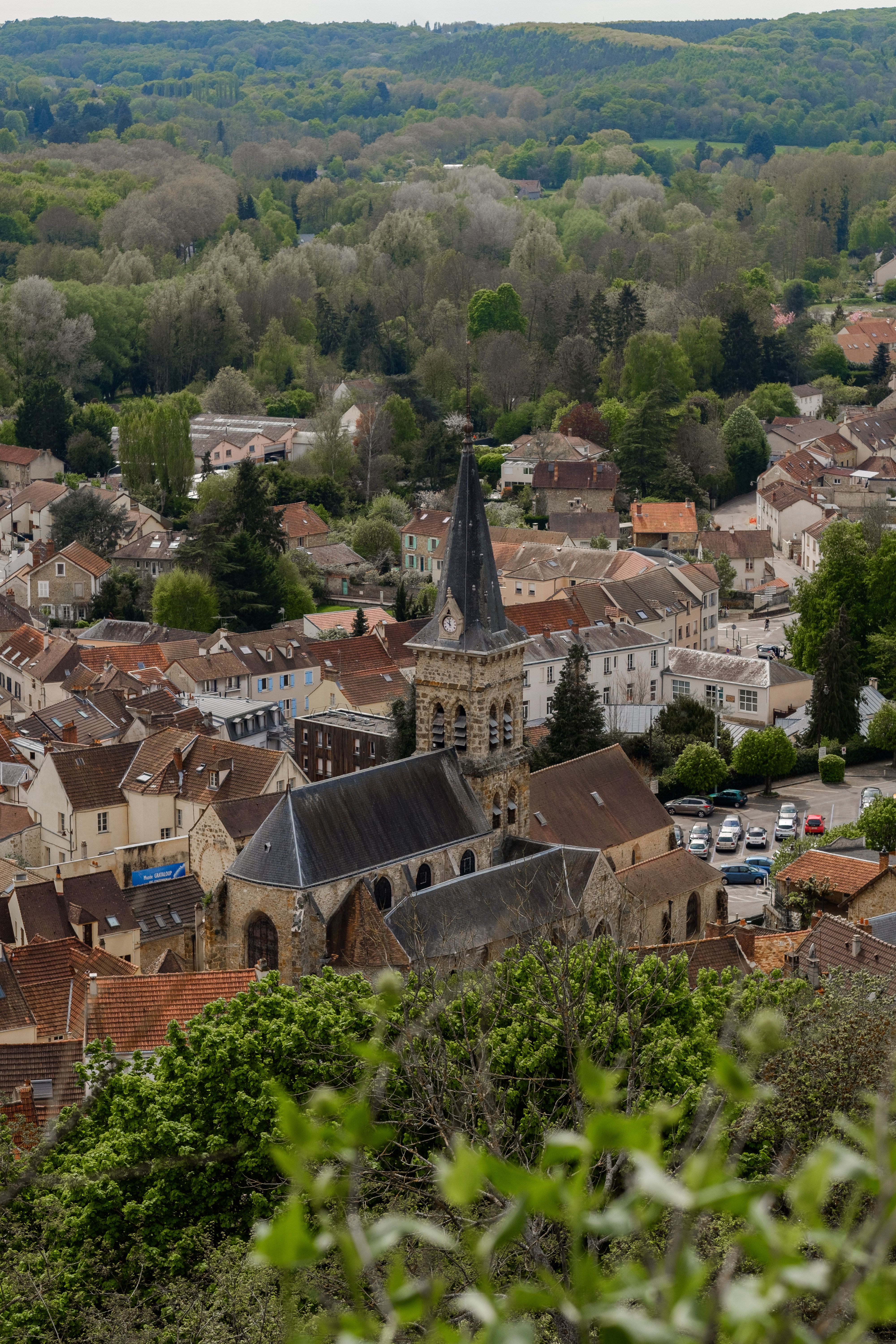 Charming French village with historic church surrounded by lush greenery.
