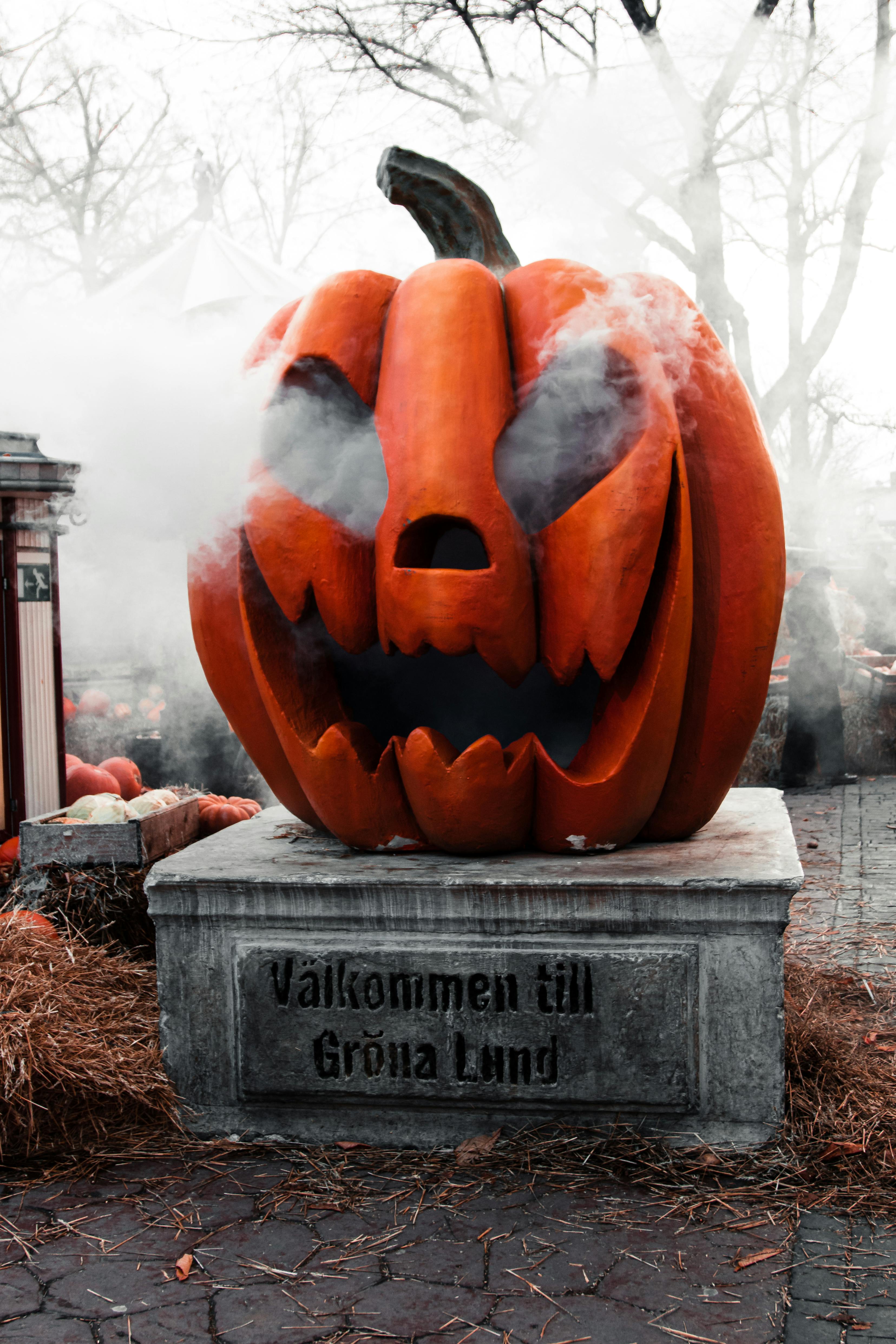 Spooky giant pumpkin statue with smoke at Gröna Lund amusement park in Stockholm.