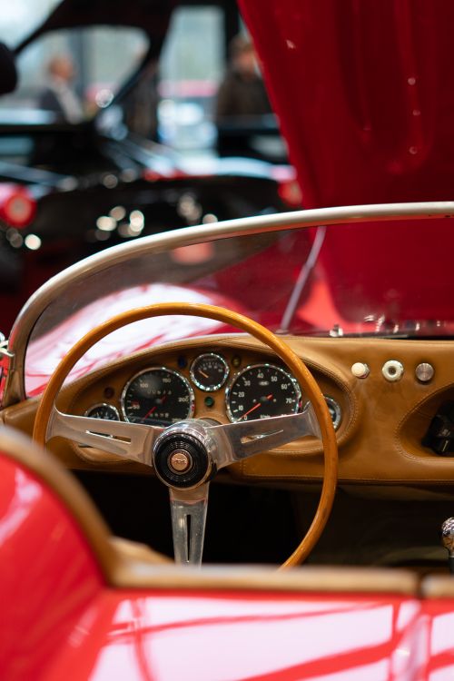 Free Close-up of a vintage sports car's interior showcasing classic instrumentation and wooden steering wheel. Stock Photo